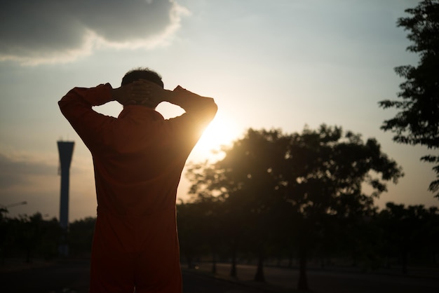 Retrato de silhueta de homem bonito asiático em uniformes de prisãoele tem muito bigode e cabelo bagunçadotailândia pessoas com raivaconceito de prisioneiro no pôr do sol