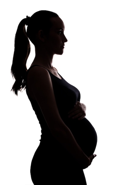 Retrato de silhueta de mulher grávida em fundo branco com as mãos na barriga, vertical