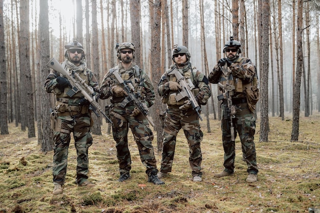 Retrato de soldados barbudos de meia-idade em um uniforme militar da floresta e capacete com fones de ouvido