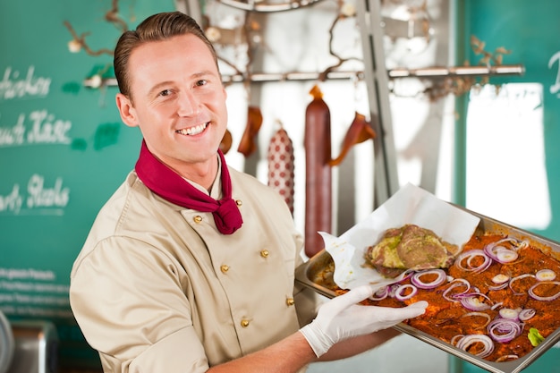 Retrato, de, sorrindo, açougueiro, com, alimento delicioso, garnished, ligado, bandeja