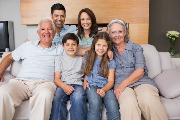 Retrato, de, sorrindo, família estendida, ligado, sofá, em, sala de estar