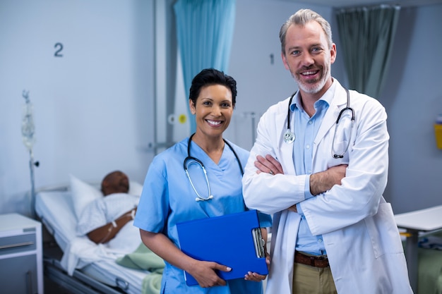 Retrato de sorrir médico e enfermeiro na enfermaria