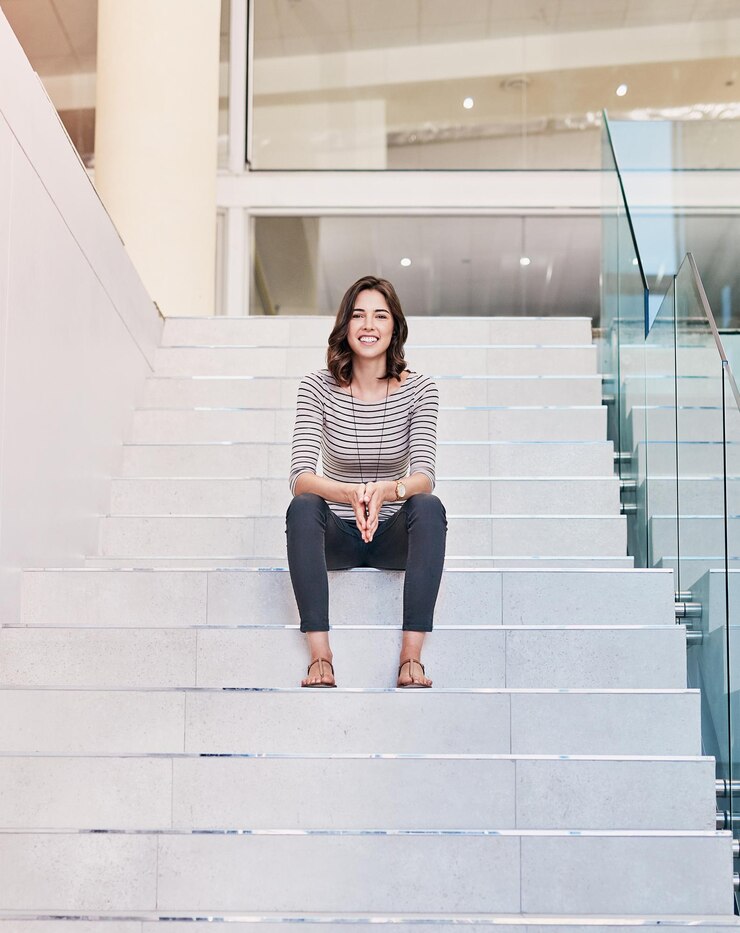 Foto retrato de sorriso e mulher de negócios em degraus no escritório para crescimento de carreira emprego ou oportunidade futura trabalho pessoa feliz e profissional nas escadas ou editor relaxar em empresa de startup criativa nos eua