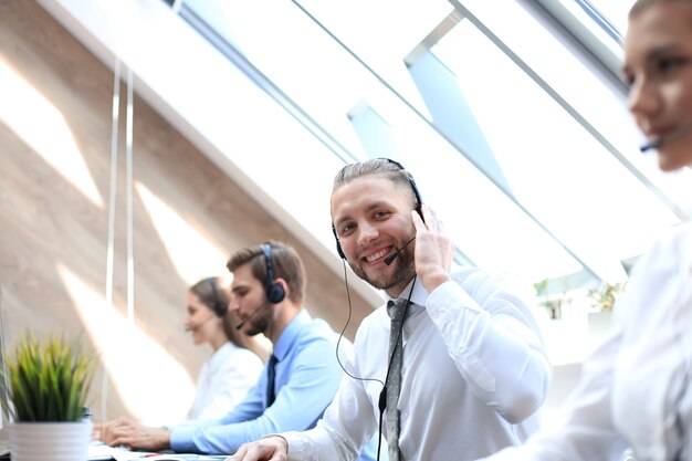 Retrato de trabalhador de call center acompanhado por sua equipe. operador de suporte ao cliente sorridente no trabalho.