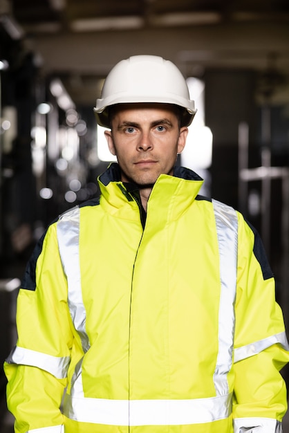 Retrato de trabalhador de engenheiro de indústria pesada caucasiano posando confiante para a câmera usando capacete de segurança