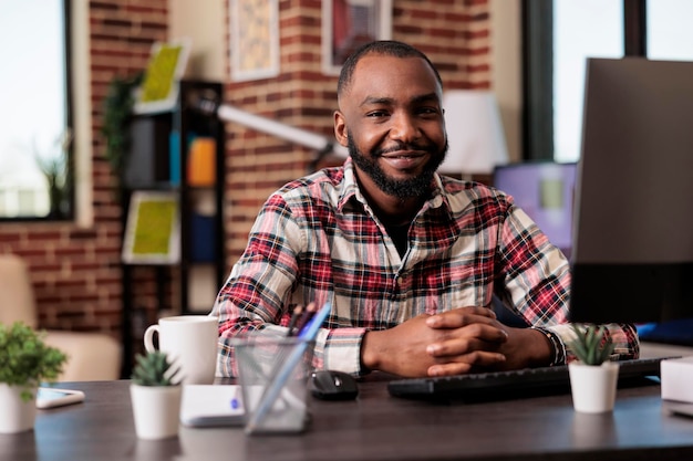 Retrato de trabalhador fazendo trabalho remoto, sentado na mesa de casa com informações de pesquisa no computador pc. freelancer masculino trabalhando no relatório do site online, enviando e-mail com dados da empresa no trabalho.