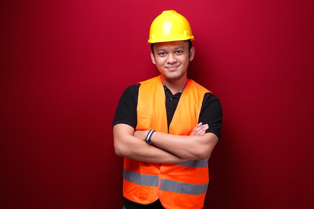 Retrato de trabalhador jovem asiático sorridente isolado em vermelho