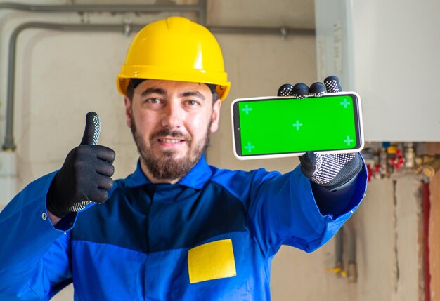 Retrato de trabalhador ou engenheiro com roupas de trabalho azuis e capacete de segurança amarelo