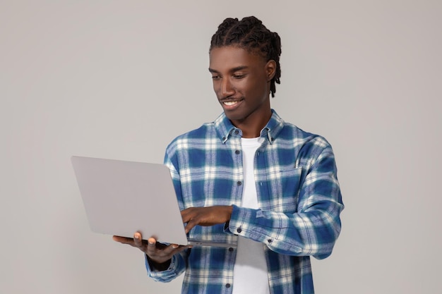 Retrato de trabalho freelancer de um homem afro-americano sorridente usando um laptop