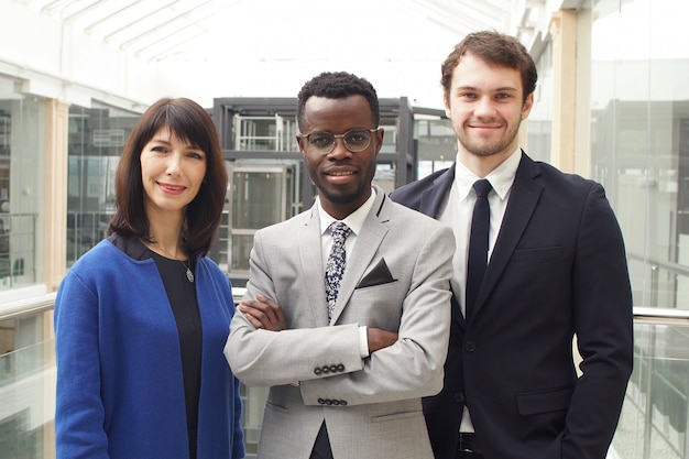 Retrato de três empresários bem sucedidos, equipe de negócios posando no escritório moderno