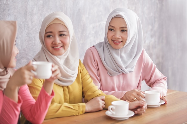 Retrato de três lindos irmãos tomando um café juntos