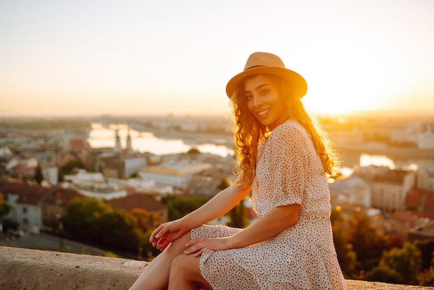 Retrato de turista feliz com chapéu ao amanhecer desfruta da paisagem urbana Viajando na Europa Conceito de turismo