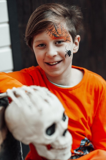 Retrato de um adolescente autêntico sincero com rosto pintado na festa de esqueletos decorados Halloween