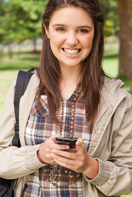 Foto retrato de um adolescente fofo com um smartphone