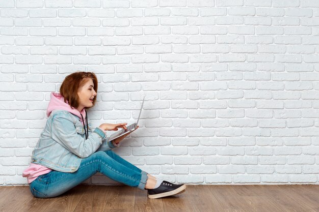 Retrato, de, um, alegre, mulher senta-se, chão, com, laptop