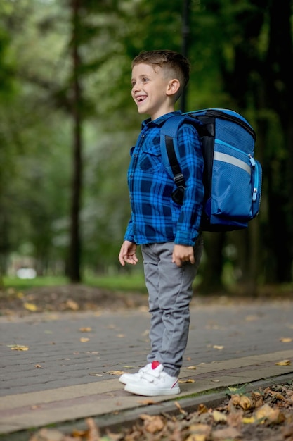 Retrato de um aluno da primeira série com uma mochila que o menino vai para a escola