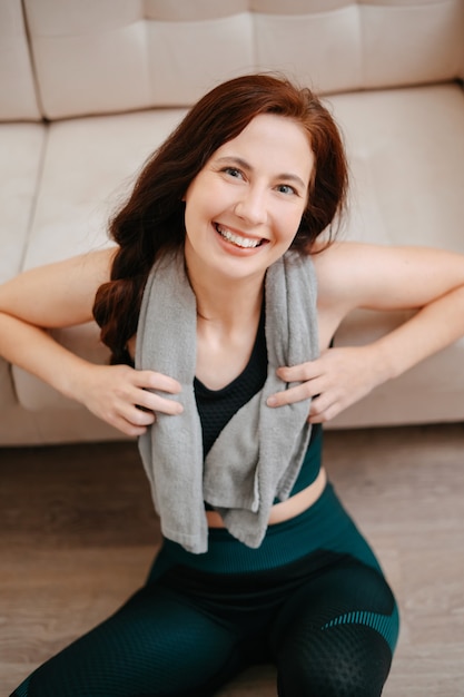 Retrato de um atleta sorridente, descansando após um treino intensivo em casa, conceito de esportes e fitness