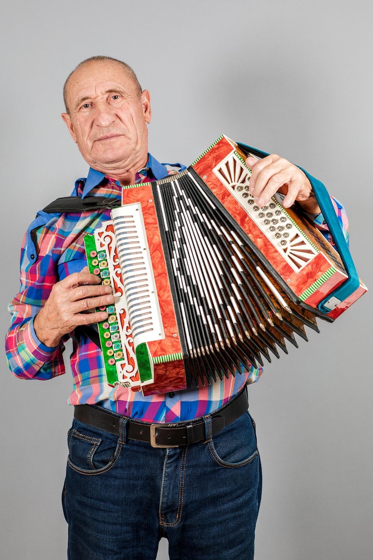 Foto retrato de um avô homem toca acordeão em um fundo cinza