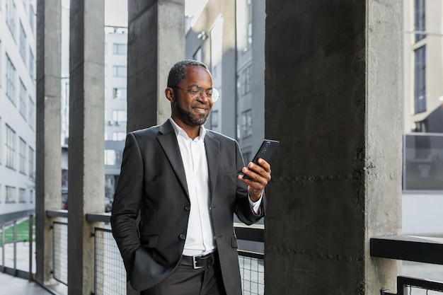 Retrato de um banqueiro empresário afro-americano de terno do lado de fora de um prédio de escritórios e