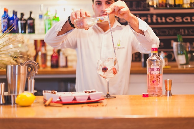 Retrato de um barman preparando uma bebida no balcão