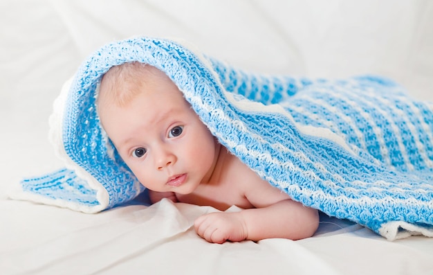 Retrato de um bebê bonito e sorridente rastejando em uma fralda. Criança de dois meses segura a cabeça.