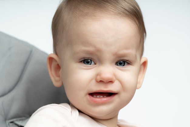 Foto retrato de um bebê de um ano chorando, chateado por estar com fome e cansado