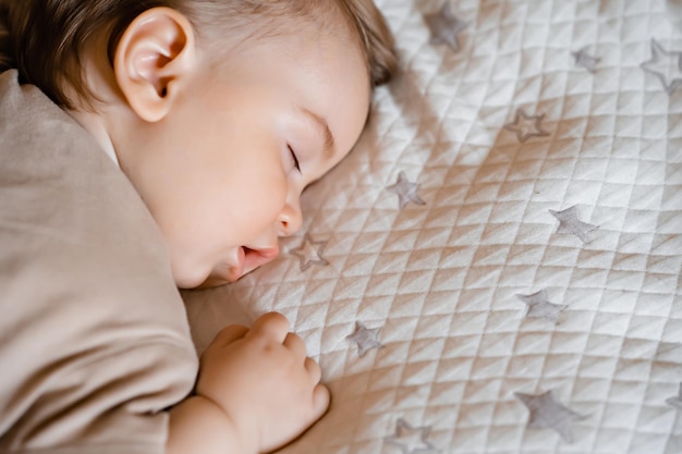 Retrato de um bebê engraçado dormindo de bruços na cama em casa Fechar a vista superior
