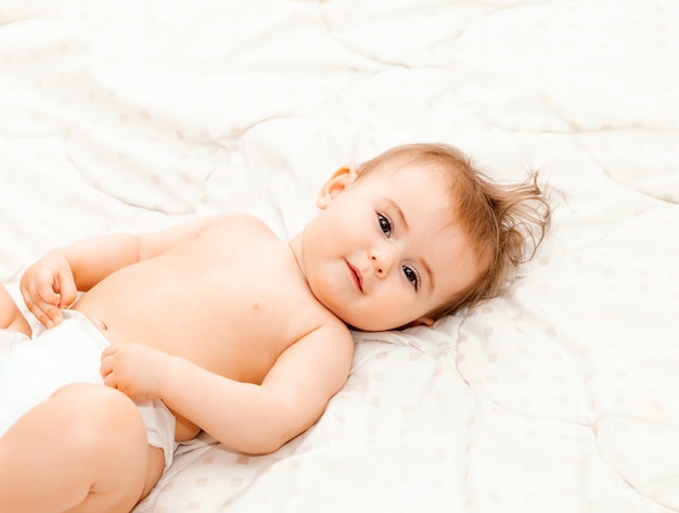 Retrato de um bebê fofo de 6 meses deitado sobre um cobertor. bebezinho feliz