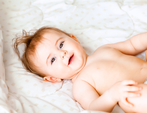 Retrato de um bebê fofo de 6 meses deitado sobre um cobertor. bebezinho feliz