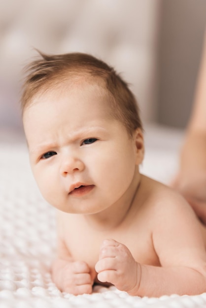 Retrato de um bebê fofo de 6 meses uma menina nua recém-nascida deitada na cama