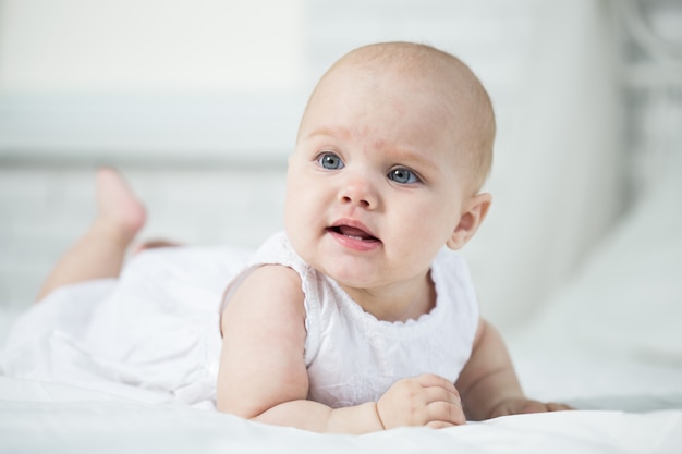 Retrato de um bebê na cama no quarto dela