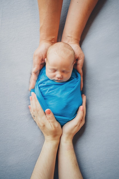 Retrato de um bebê recém-nascido deitado nas mãos dos pais
