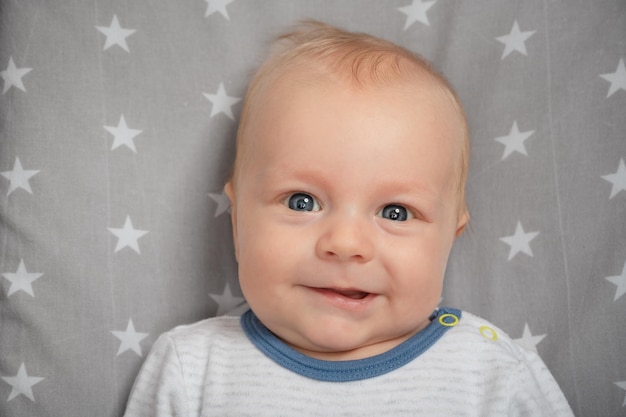 Foto retrato de um bebê recém-nascido sorridente com a boca aberta fechada criança sorridente feliz com olhos azuis