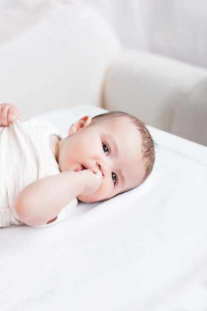 Retrato de um belo bebê deitado na mesa na sala de estar