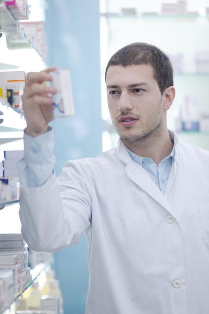 Foto retrato de um belo jovem farmacêutico farmacêutico de pé na farmácia