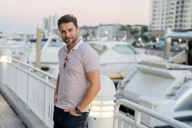 Retrato de um belo modelo masculino ao ar livre estiloso vestido de polo fashion masculino posando na rua