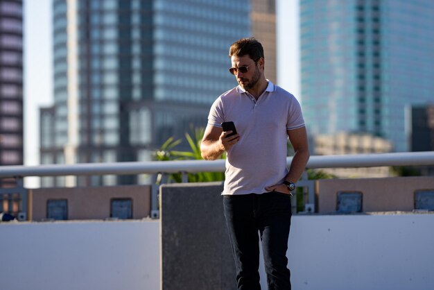 Retrato de um belo modelo masculino ao ar livre, um homem elegante vestido de polo, um homem posando na moda.