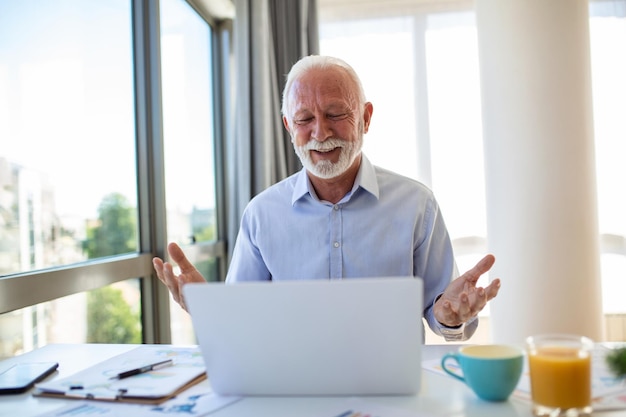 Retrato de um belo treinador de negócios sênior fazendo uma videochamada falando com a câmera explicando algo Webinar videoconferência conceito de reunião on-line