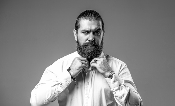 Foto retrato de um bonito homem barbudo de camisa branca, barba e bigode masculino