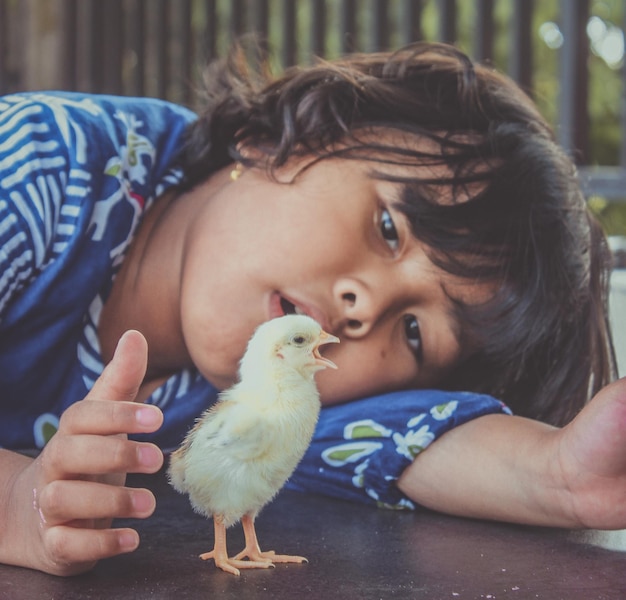 Foto retrato de um bonito menino segurando um pássaro