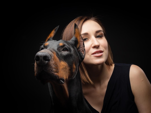 Foto retrato de um cão doberman com uma dona de menina