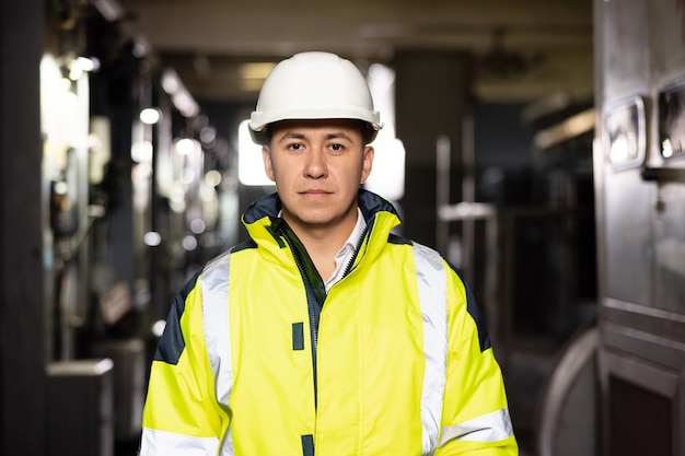 Retrato de um capataz bonito e confiante com capacete de segurança olhando para a câmera na importação de logística de exportação