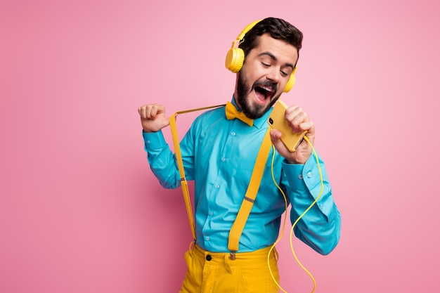 Retrato de um cara barbudo sonhador cantando segurar o telefone e ouvir música boné