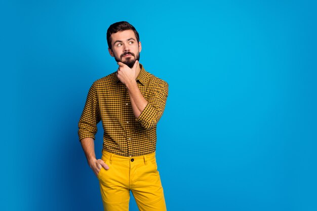 Retrato de um cara interessado e pensativo, pensar pensamentos, escolher decisões sobre o futuro fim de semana olhar copyspace tocar o queixo dedos usar roupa xadrez isolada sobre a cor azul