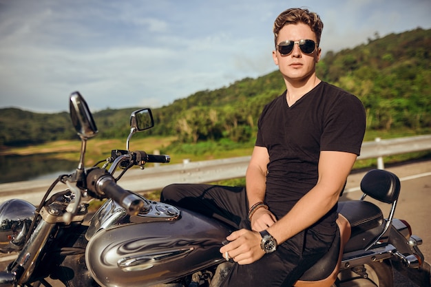 Foto retrato de um cara sentado em uma motocicleta