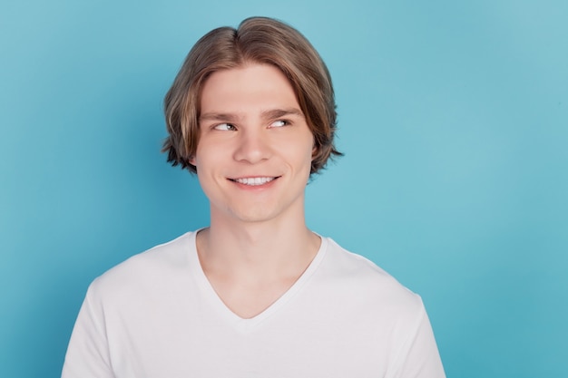 Retrato de um cara sorridente sonhando isolado em um fundo azul