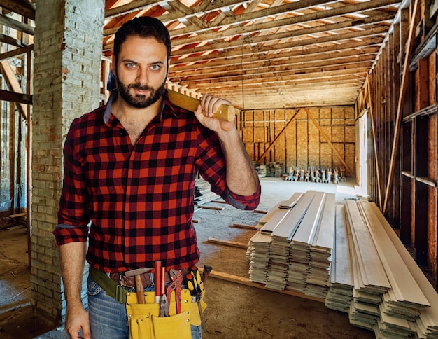 Retrato de um carpinteiro em uma casa de madeira em construção