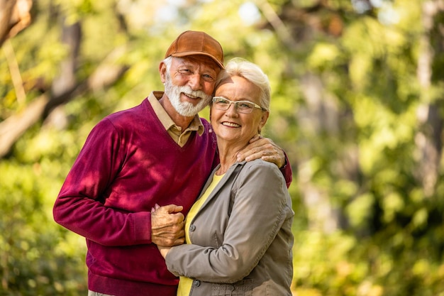 Foto retrato de um casal americano idoso no parque olhando para a câmera