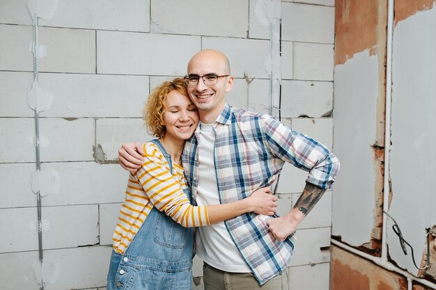 Retrato de um casal apaixonado dentro de um apartamento em construção.