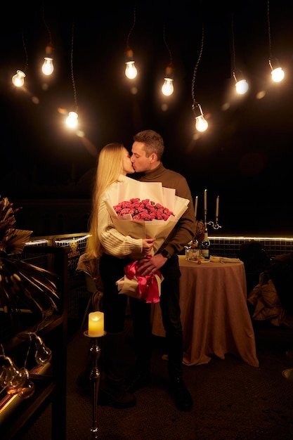 Foto retrato de um casal atraente segurando um buquê de rosas